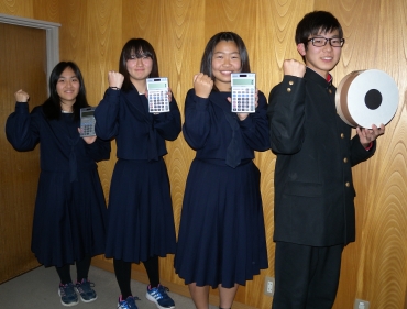 「優勝するぞ!」。的や電卓を手にガッツポーズを決める(右から)山本君、朝倉さんら=東愛知新聞社で