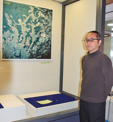 鉄砲玉の発見場所を示した地図(左上)と湯浅学芸員=新城市設楽原歴史資料館で