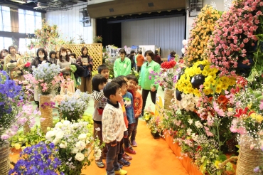 花の造形物を眺める子どもたち=田原市総合体育館で