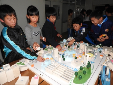 模型を使ってまちをプロデュースする児童ら=桜町小学校で