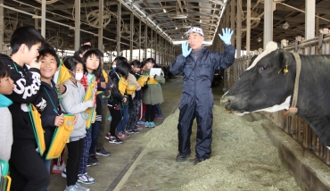 伊藤さんから酪農の仕事について学ぶ児童ら=田原市石神町で