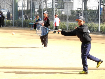 軽快なラケットさばきを見せる豊川クラウンの吉松君㊨=豊川市営庭球場で