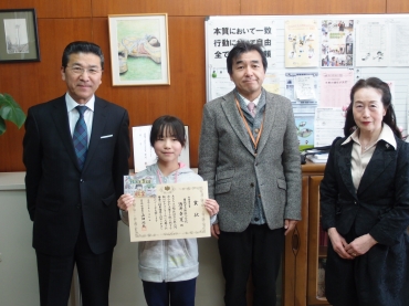 山田署長㊧から表彰状を贈られた酒井さん(左から2番目)=豊橋市立野依小学校で