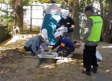 蒲郡市中央小学校で行われた訓練で排せつ溝で設置する住民ら(2014年11月23日、市防災課提供)
