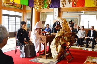親族が見守る中、仏前で行われた山本さんと豊田さんの結婚式=西光寺で