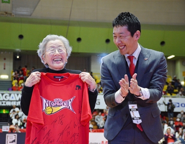 選手のサイン入りTシャツを手にする高須さん、右は浜武社長=同市総合体育館で