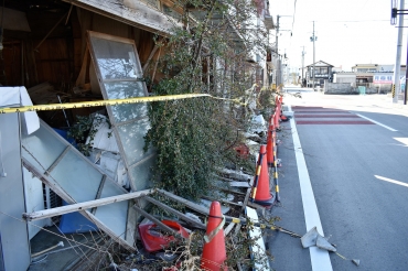 倒壊しかけた家屋の存在が、復興の道のりの長さを物語る=福島県浪江町で
