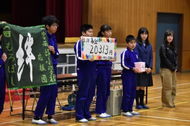 「もろ星☆」の児童から義援金を贈られる梅岡さん㊨と増野さん(左隣)=一宮西部小学校で