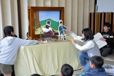 命がけで職務を全うする江崎巡査の姿を描いた紙芝居「江崎巡査物語」を披露する児童たち=衣笠小学校で