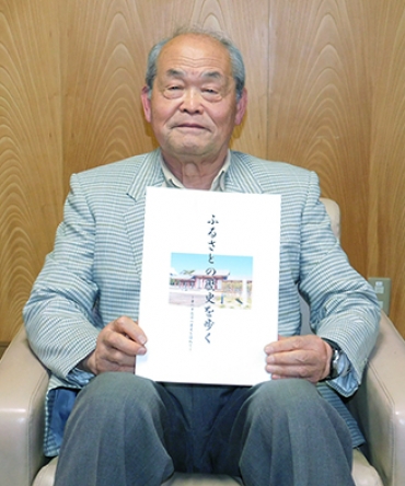 著書「ふるさとの歴史を歩く」を手にする鈴木さん=東愛知新聞社で