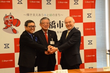 協定書に署名後、握手する(左から)加藤社長、佐原市長、大西学長=豊橋市役所で