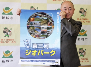 作成したポスターを手にする加藤館長=新城市役所で