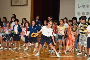 ブラジルの楽器を手に歌って踊る外国籍の子どもたち=代田小学校で