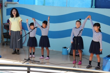 「ぼくらの竹島水族館」を披露する金子さんと小学生たち=蒲郡市竹島水族館で