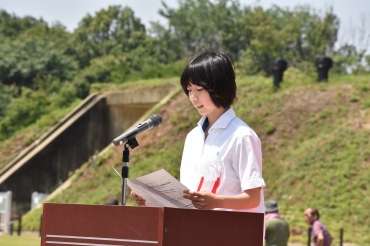 火薬庫の遺構を背に、大林さんの日記を読む小島さん=豊川海軍工廠平和公園で