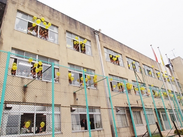 メッセージを付けた黄色い風船を空へ放つ生徒ら=豊橋市立章南中学校で