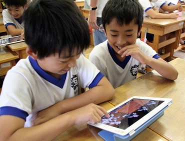 iPadで物語を見る児童たち=同