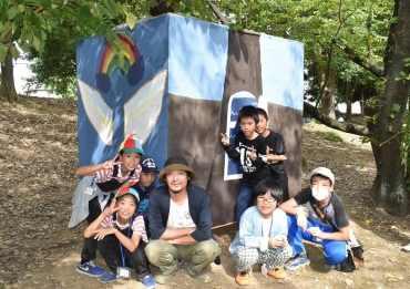 原田さん㊥の助言で、周囲の景色と同化した秘密基地を作った子どもたち=桜ヶ丘公園で
