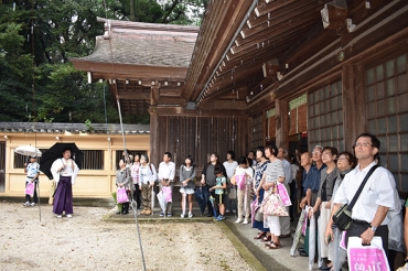 三宅さん㊧の案内で中庭を見学するセミナーの参加者ら=砥鹿神社で