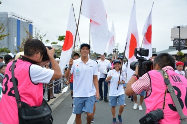 市民の声援に応えながらパレードする五十嵐選手ら日本選手団=田原市内で