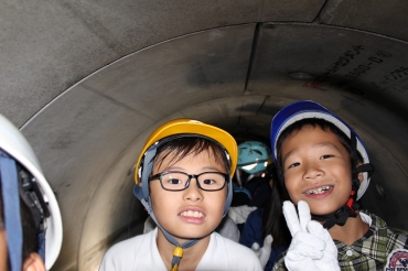 トロッコに乗って下水道管を見学する児童ら=羽根井ポンプ場で