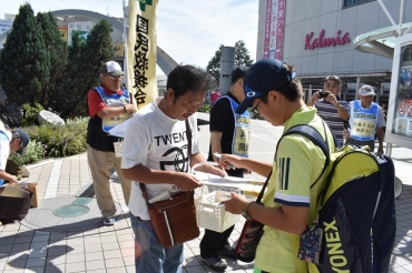 若い男性から署名の協力を得る田邉氏の支援者=豊橋駅東口で