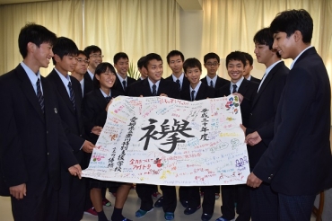 豊川特別支援学校の生徒㊨から応援旗を贈られる豊川工陸上競技部員=豊川工業高校で