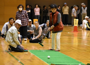 仲間が見守る中、スカットボールに挑戦する御津校区の女性=豊川市総合体育館で