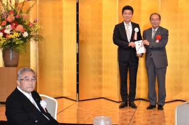 山脇市長㊨に寄付金を贈る土井社長。左手前は土井会長=ホテルアソシア豊橋で