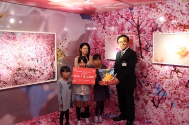 1万人目の来場者となり、ぬいぐるみを贈られる田口さん親子=桜ヶ丘ミュージアムで
