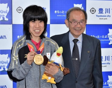 金メダルを手に山脇市長に優勝を報告した蒔田さん㊧=豊川市役所で