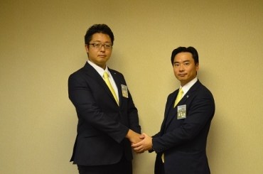 固い握手を交わす神谷理事長㊧と次期理事長の村井氏=ロワジールホテル豊橋で