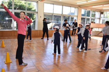 小野さん㊧と一緒にラジオ体操を行う子どもたち=豊川特別支援学校で