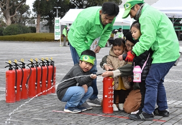水消火器を使ったゲームを体験する子どもたち=豊川市総合体育館前で