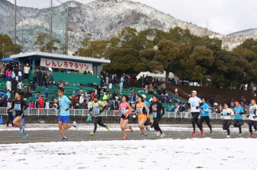 雪が積もる会場でランニングシャツで走る参加者も=県営新城総合公園で
