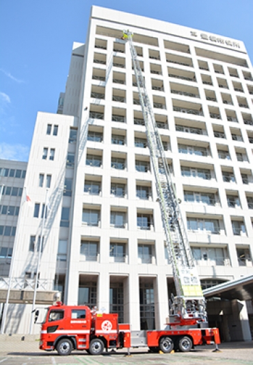 はしごを伸ばし13階の高さから要救助者を助けるレッドジラフ54=豊橋市役所で