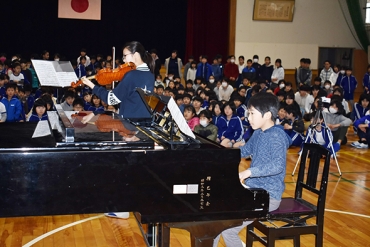 ピアノを弾く朝倉君㊨とバイオリンを奏でる角谷さん=豊川小学校で