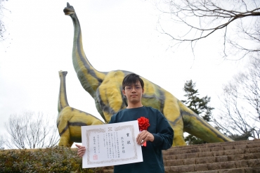 デザインを担当した熊谷さん、後ろは新しい色になったブラキオサウルスの親子=豊橋市自然史博物館で