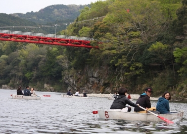 手こぎボートで笠岩橋(左上)などを見て回る参加者ら=新城市の桜淵公園で