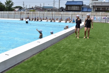 敷かれた人工芝を歩いてプールの授業を楽しむ子どもたち=豊川市立中部小で