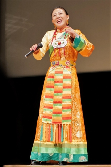 美しいチベットの民族衣装でチベット歌曲を披露するヤンジンさん=田原市渥美文化会館で
