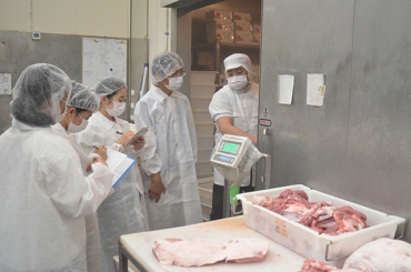 豚肉の加工現場を視察する学生ら=和広産業植田工場で