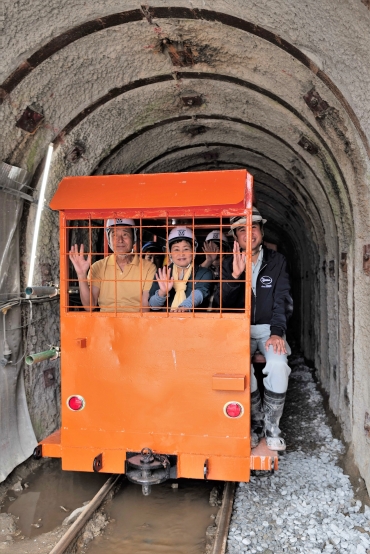 トロッコに乗ってトンネルを走る見学者たち=田原市赤羽根町の赤羽根施工ヤードで