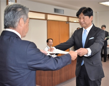 宮川委員長から当選証書を渡される竹本氏㊨=豊川市役所で