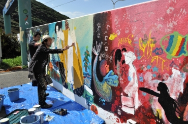 ウォールアートを描くコータローさん(手前)と田原市民=伊良湖クリスタルポルトで