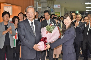 職員から花束と拍手を贈られ、退庁する山脇市長㊧=豊川市役所で