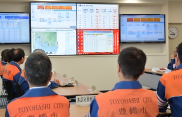 新たに導入した大型スクリーンに映しだされる災害情報=豊橋市役所で