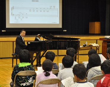 ピアノを弾きながら音楽の歴史などを解説する三枝氏=石巻小学校で
