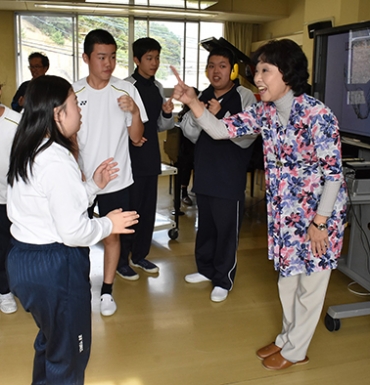 子どもたちと歌で触れ合う名倉さん㊨=豊川特別支援学校で
