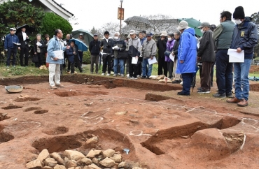 林さんの案内で、発掘調査現場を見学する地元住民ら=三河国分寺跡で